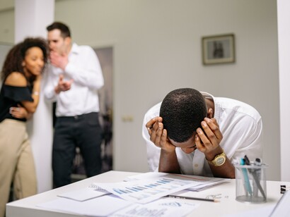 Two people bullying a man. Bullying can extend beyond high school
