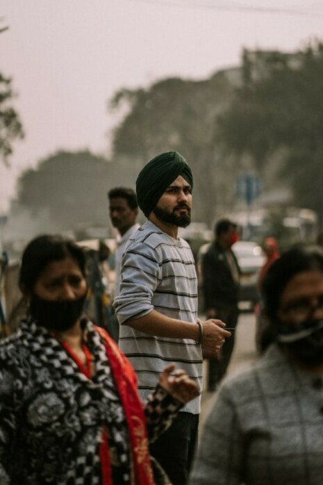 A man wearing a turban stands on the side of a road in Kolkata, West Bengal, India, reflecting the complex cultural and historical identities that shape the region's ongoing challenges with unity and division