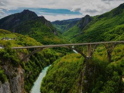 The iconic Đurđevića Tara Bridge in Montenegro gracefully arches over the Tara River, showcasing engineering brilliance amid stunning natural surroundings