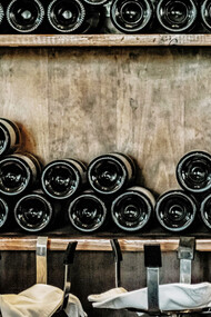 The sophisticated allure of black wine bottles elegantly displayed on a rustic wooden shelf, adding a touch of timeless charm to your wine collection