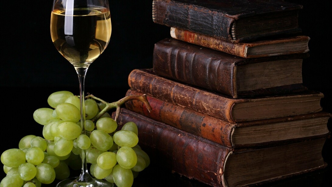 Una copa de vino junto a unos libros