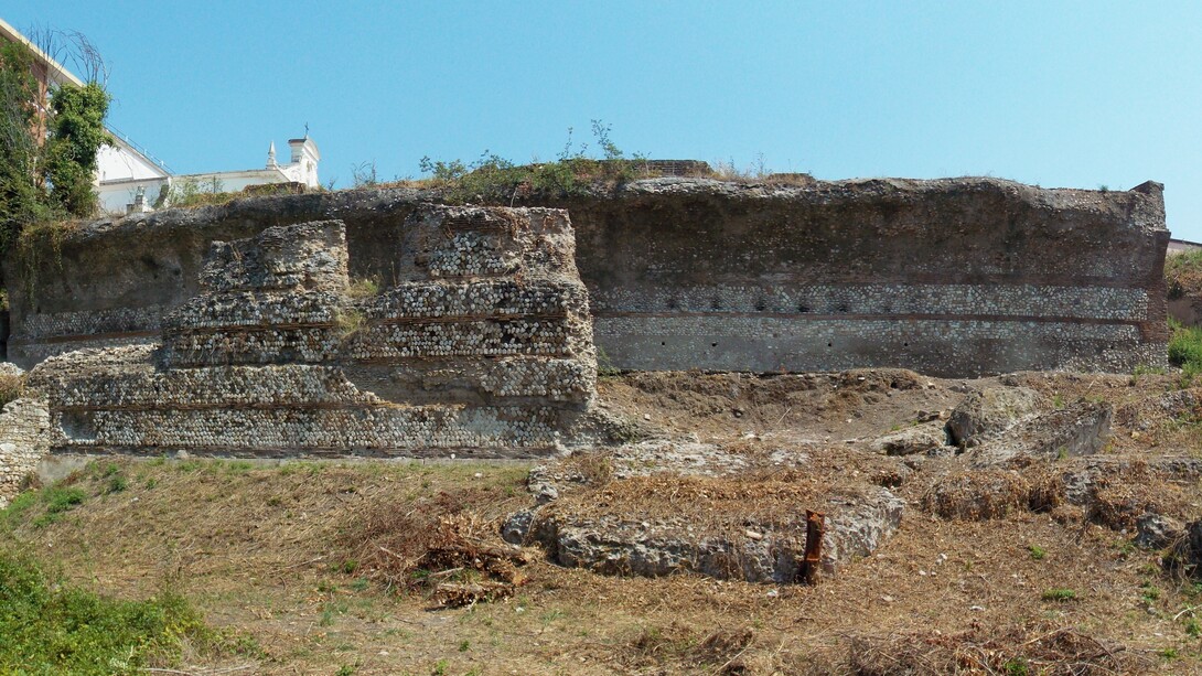 Vista esterna del braccio ovest del corridoio principale. A sinistra si vede il vano in cui era costruita la scala fra il piano del corridoio e le campagne. Verso il centro è il tratto di parete esterna conservata. In basso a destra sono i blocchi crollati da tale parete. Benevento, Italia