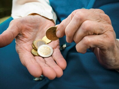 Una persona mayor contando monedas