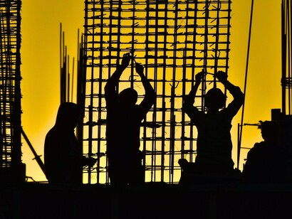 Construction workers assembling a reinforced framework, representing the need to build lasting foundations for social change