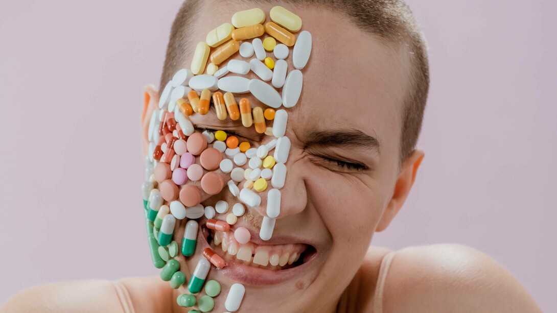 Happiness on a person's face that also has a collection of pills