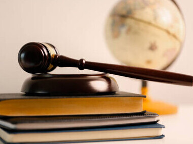 The concept of law and justice represented through a court theme, with law books and a globe symbolizing international legal systems