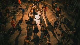 Pessoas dançam na rua: o popular passeia no cotidiano pelos rituais e pelas narrativas
