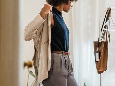 A woman getting dressed in her room before work