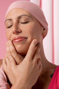 Woman recovering from breast cancer, adorned in a pink scarf