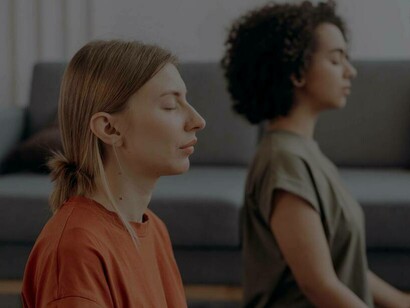 Two women concentrate and remain persistent as they meditate 