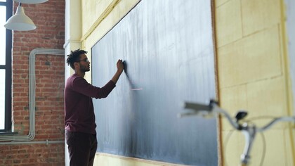 Teacher writing on the board of a classroom