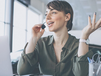 In the midst of COVID-19 precautions, a woman works in a recording studio, donning a mask while utilizing digital tools on her computer, showcasing the adaptation to digitalization in the workplace